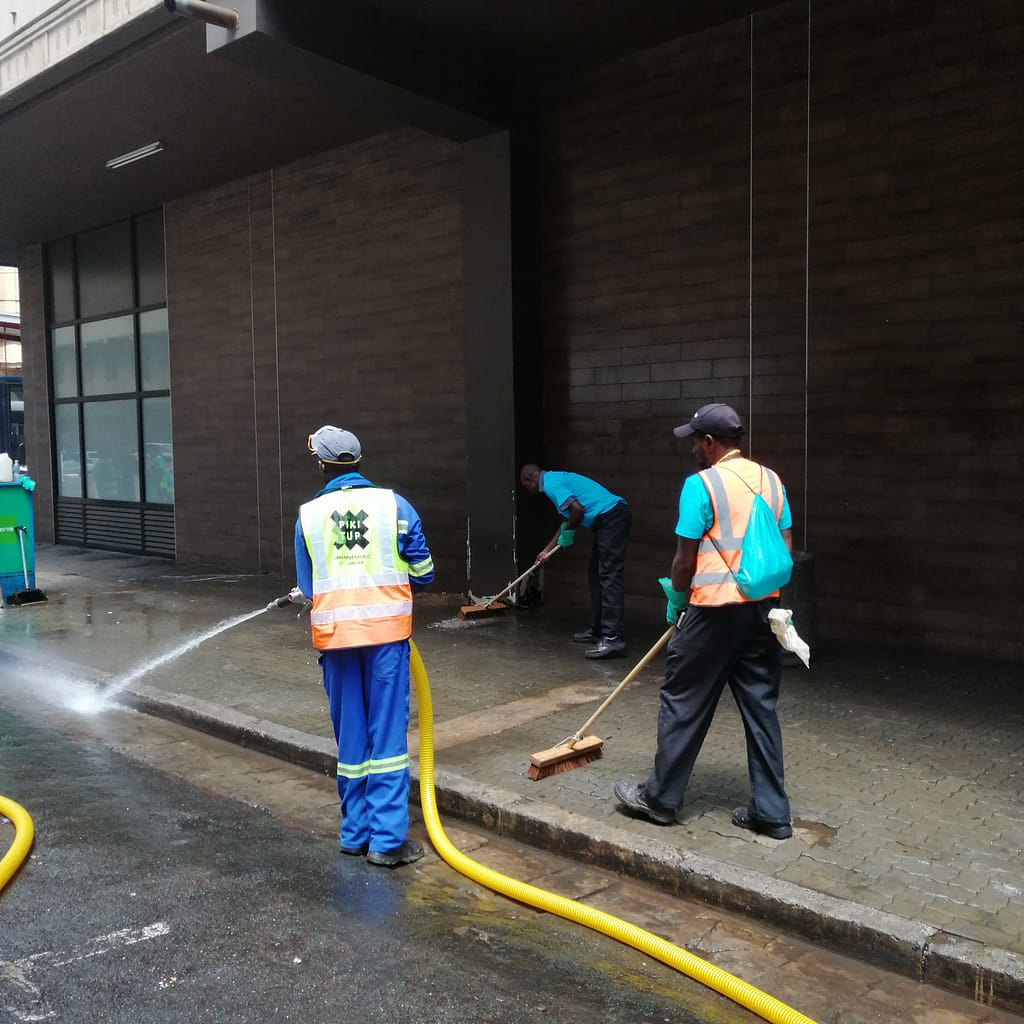 Man Spraying water on pavement